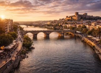 Река Гвадиана — главный природный ориентир Бадахоса и одна из тех деталей, без которых невозможно понять характер города. Она не просто делит территорию, а формирует пространство для жизни, прогулок и встреч. Именно вдоль воды выстраивается спокойный, немного созерцательный ритм приграничной столицы Эстремадуры. Набережные Бадахоса — это сочетание исторической атмосферы и современной городской среды. Широкие пешеходные зоны, велодорожки, зелёные аллеи и смотровые площадки создают ощущение открытого пространства. Здесь гуляют семьи, бегают спортсмены, пожилые жители обсуждают новости, а вечером пары встречают закат. Свет Атлантики, смягчённый внутренним климатом региона, делает воду особенно выразительной в золотые часы. Мосты через Гвадиану — важные архитектурные акценты города. Старый мост с каменными арками напоминает о средневековой истории и стратегическом значении Бадахоса как приграничного пункта. Современные переправы, напротив, подчёркивают развитие инфраструктуры и связь с Португалией. Они не спорят с прошлым, а аккуратно вписываются в панораму. С воды открывается один из самых выразительных видов на город: силуэт крепостных стен Алькасабы, башни, купола и белые фасады домов. Гвадиана отражает их, создавая двойной пейзаж — реальный и зеркальный. В тёплое время года здесь проходят небольшие городские мероприятия, спортивные активности и локальные фестивали. Важно и экологическое значение реки. Вдоль берегов обустроены зелёные зоны, где можно увидеть птиц и характерную для региона растительность. Это делает пространство не только урбанистическим, но и природным. Гвадиана в Бадахосе — это граница и связующее звено одновременно. Она напоминает о стратегической роли города в истории, но при этом создаёт спокойную, открытую атмосферу современной жизни у воды.