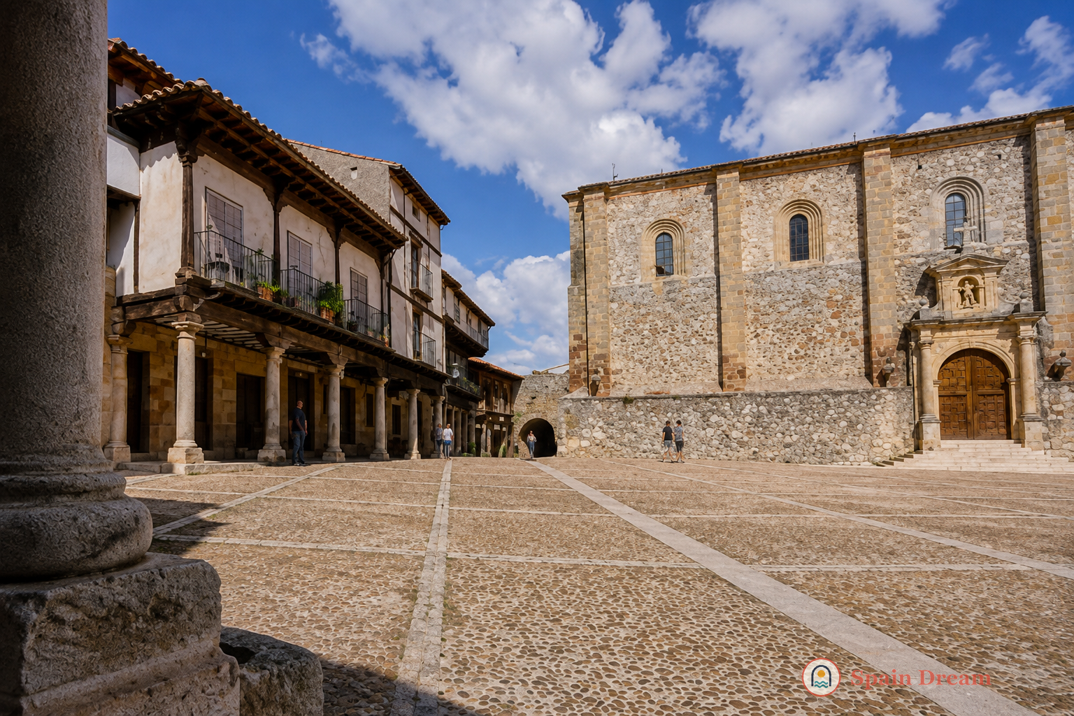 Каменная башня Castillo de Atienza на высокой скале над черепичными крышами исторического города