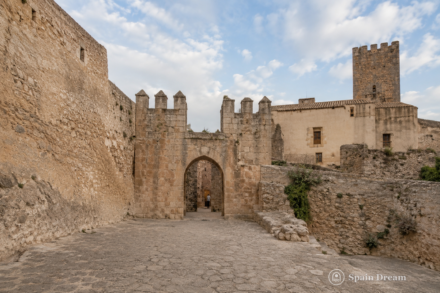 Castillo de Buñol с каменными башнями, внутренними жилыми домами и старым кварталом у подножия