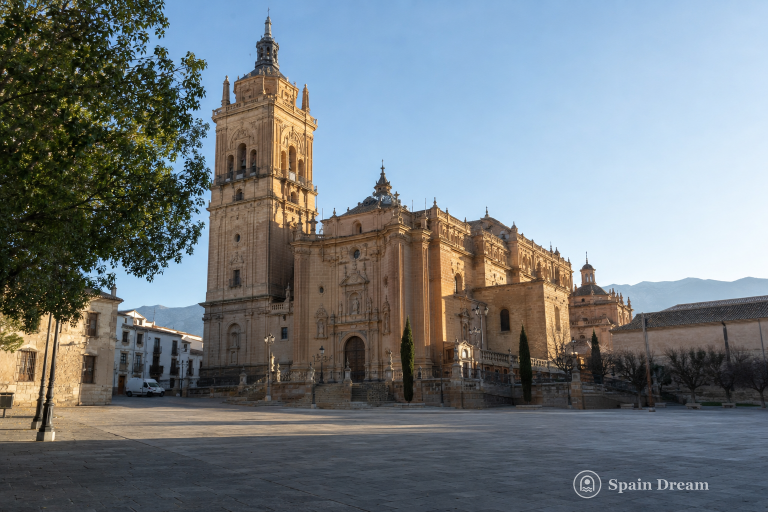 Catedral de la Encarnación в Гуадисе с высокой башней, барочным фасадом и историческими домами вокруг