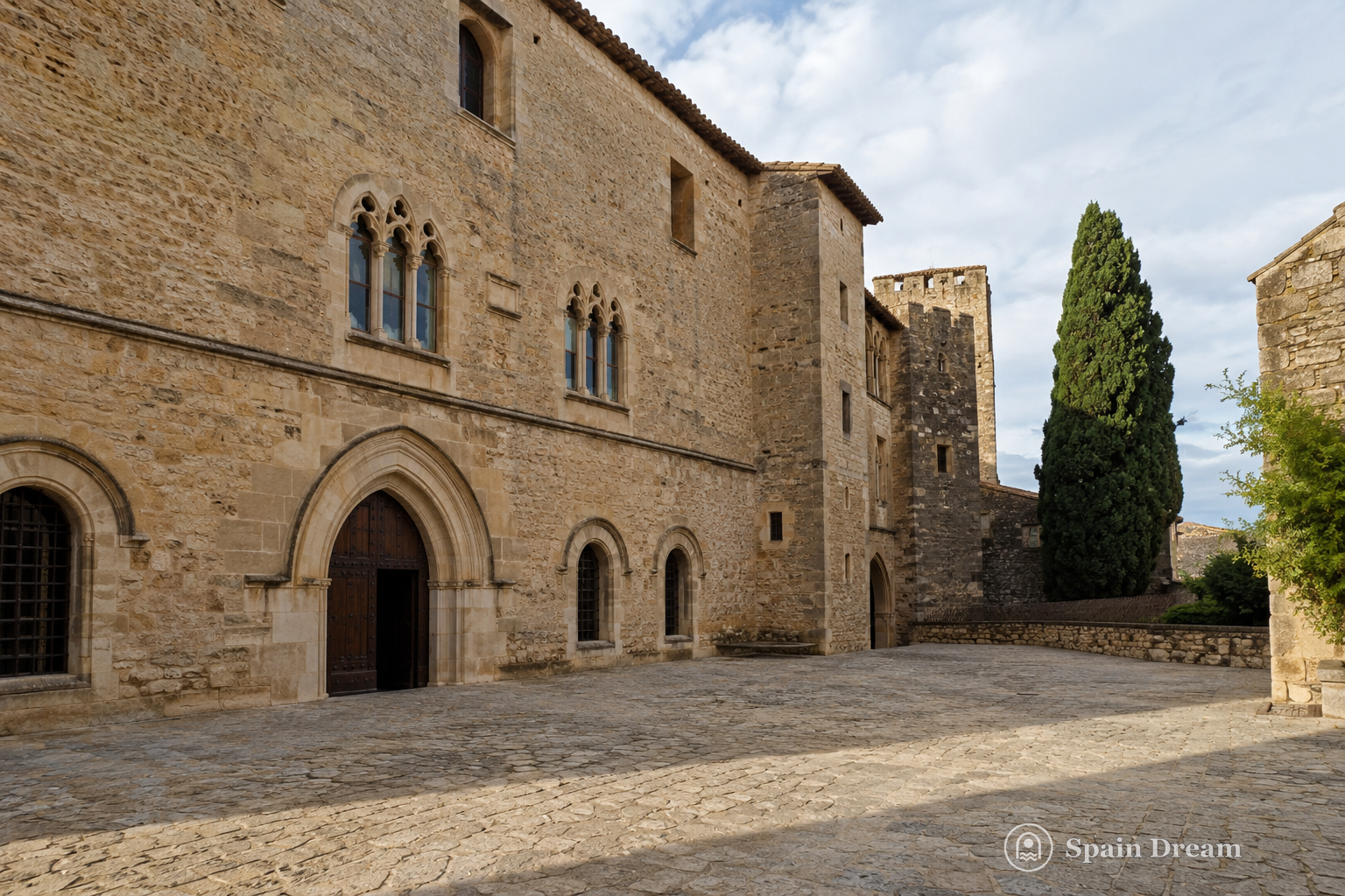 Романский Castell Palau в Ла-Бисбаль-д'Эмпорда с массивной каменной башней и старой площадью