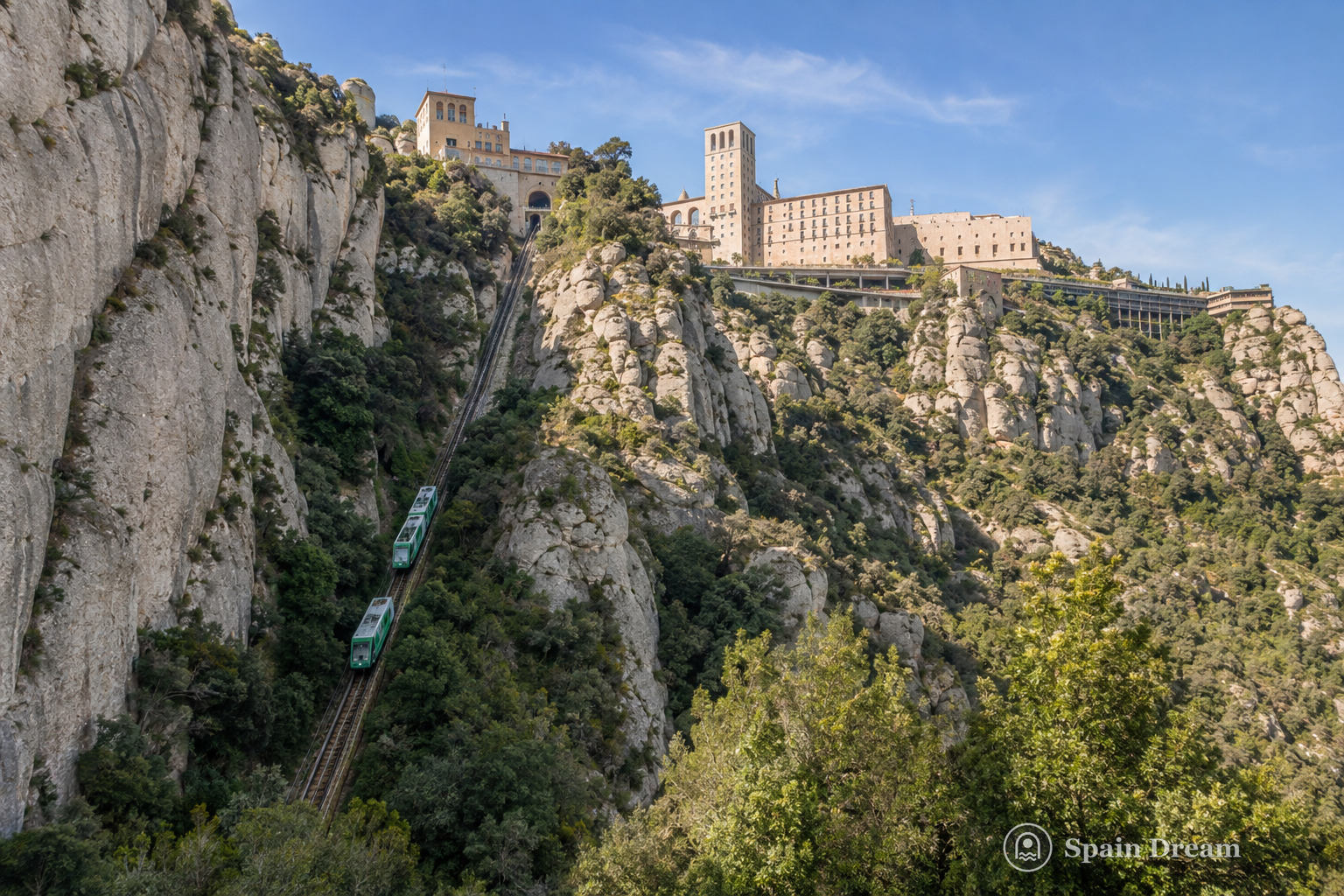 Cremallera de Montserrat поднимается над Монистроль-де-Монтсеррат по склону к зубчатым вершинам массива