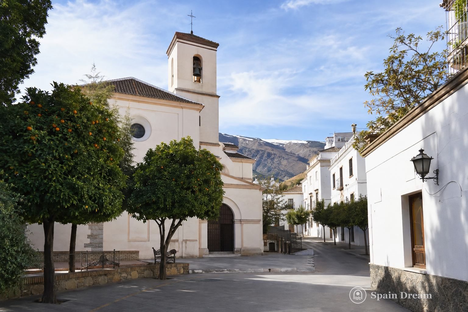 Светлая церковь Nuestra Señora de la Expectación в центре Орхивы, апельсиновые деревья и белые фасады вокруг