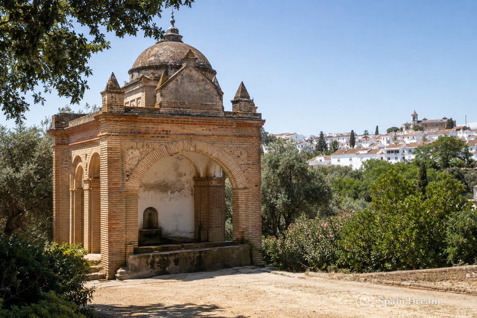 Историческая La Fontanilla среди зелени и белая застройка Палос-де-ла-Фронтера на возвышенности