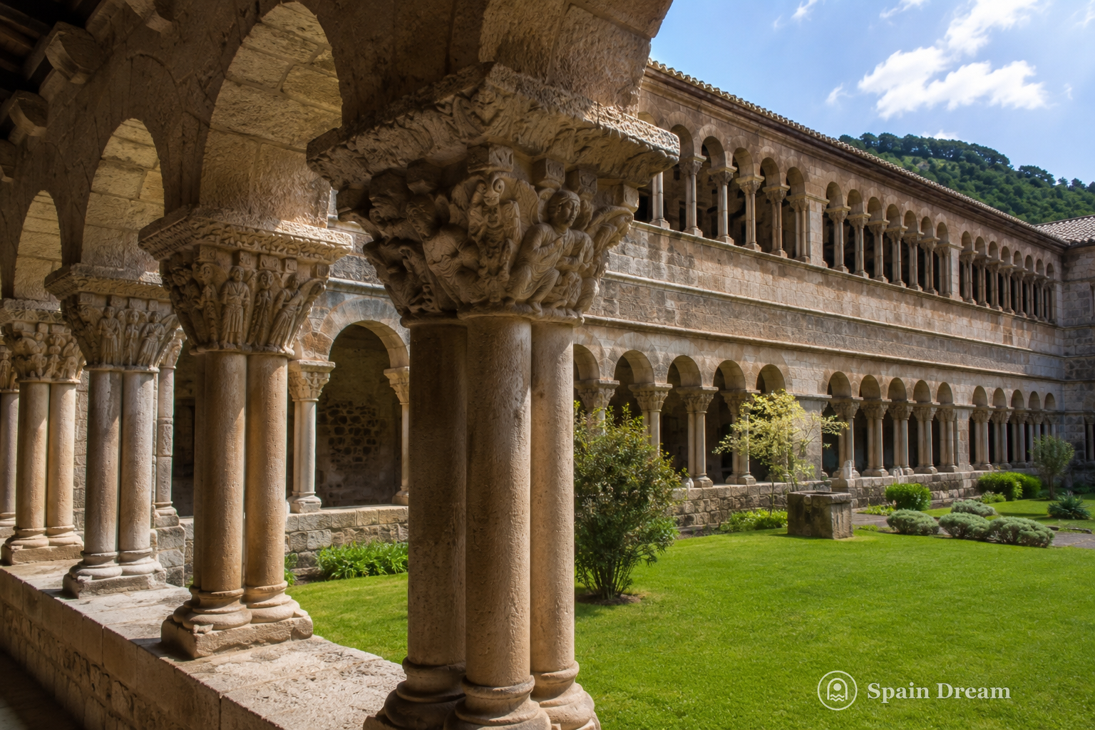 Романский клуатр монастыря Santa Maria de Ripoll с двойными аркадами, резными капителями и зелёным внутренним двором