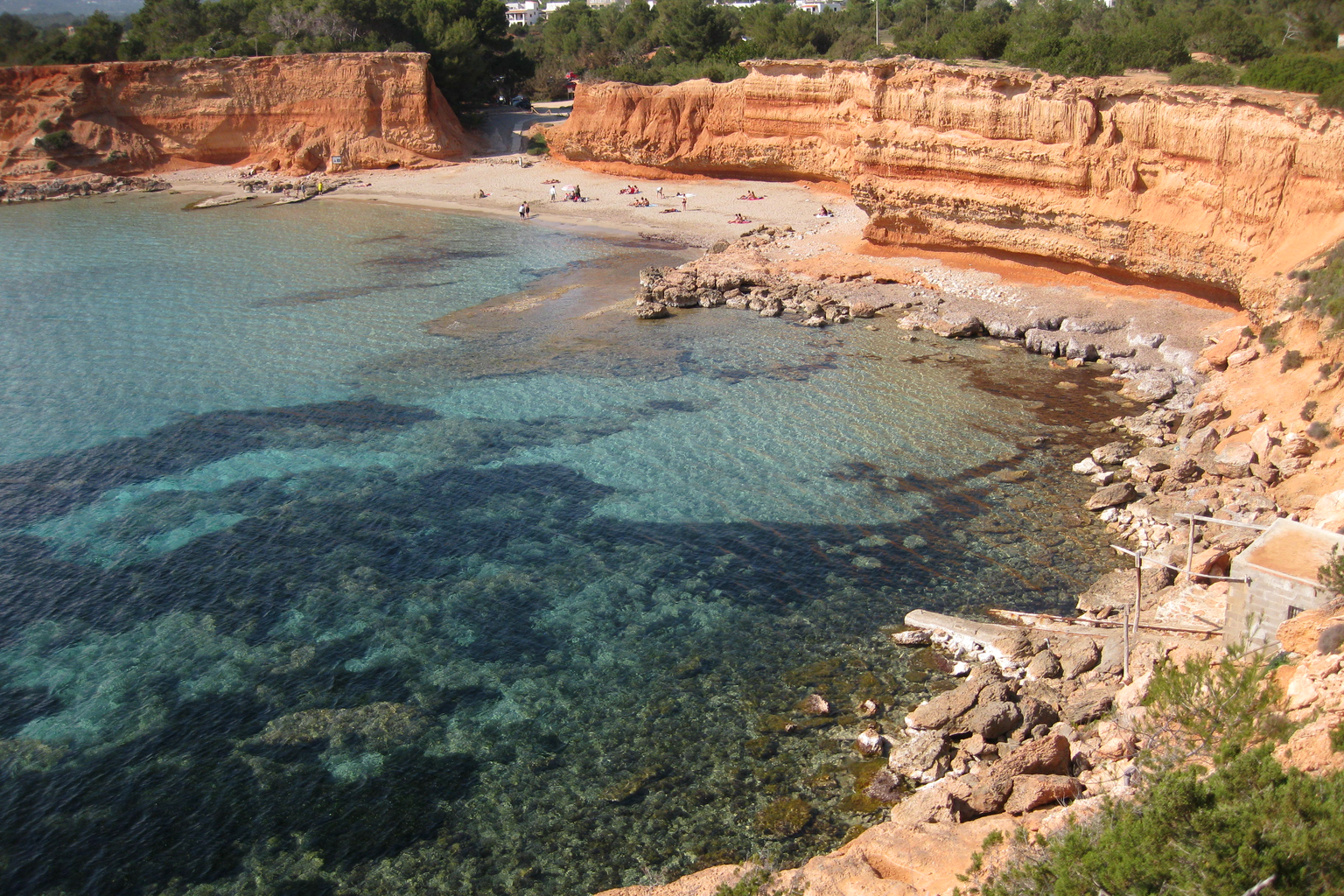 Бухта Sa Caleta с красными береговыми обрывами и прозрачной водой на юге Ивисы