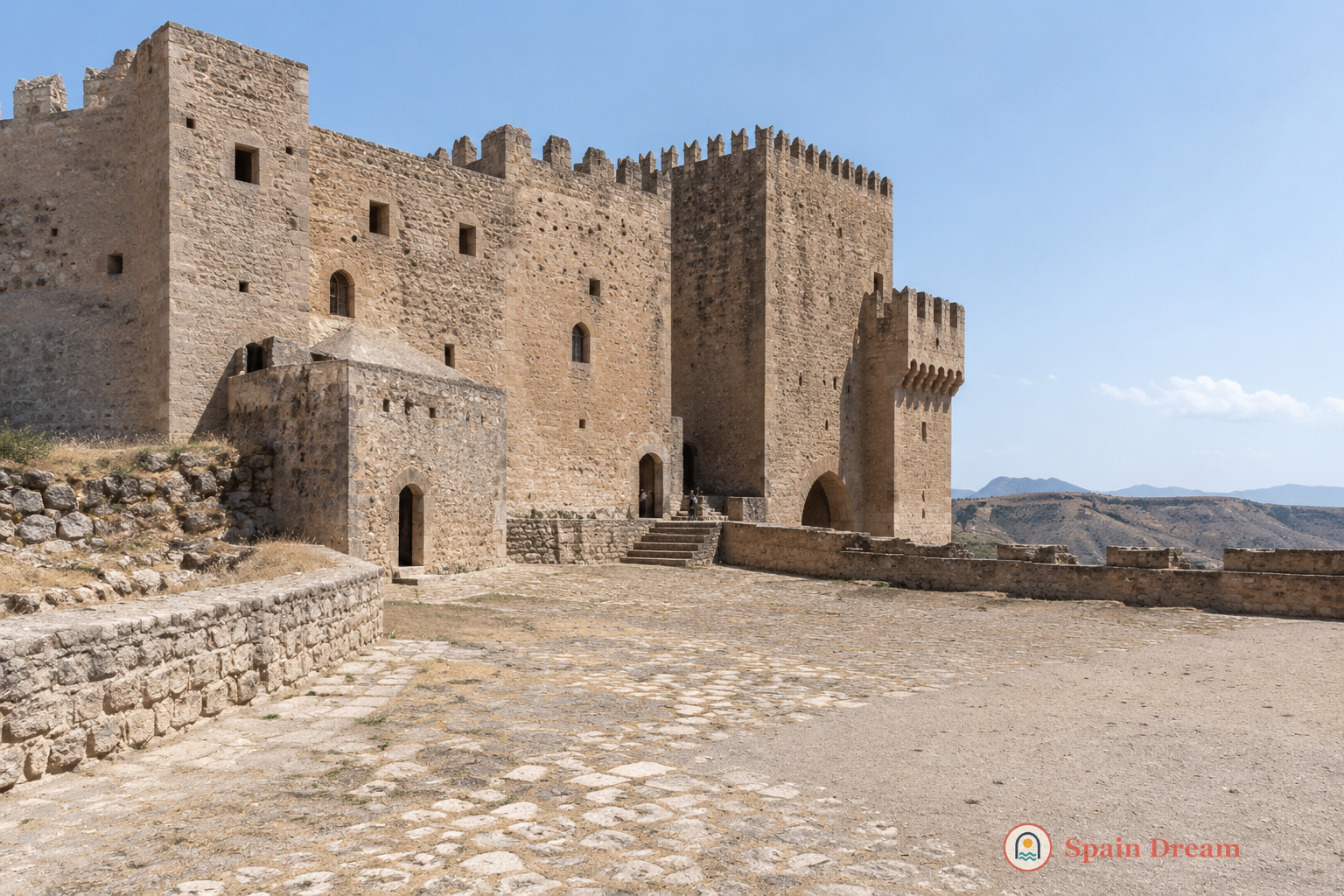 Castillo de los Fajardo над Велес-Бланко с массивными каменными стенами, Torre del Homenaje и белыми домами у подножия